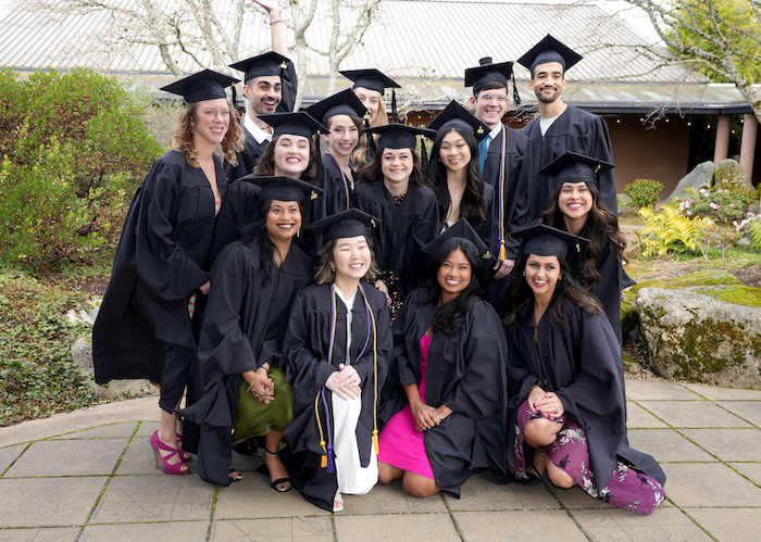 UW GCGP class of 2023 gathered closely together outdoors at their graduation