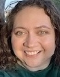 Lauren looks at the camera wearing a green shirt.