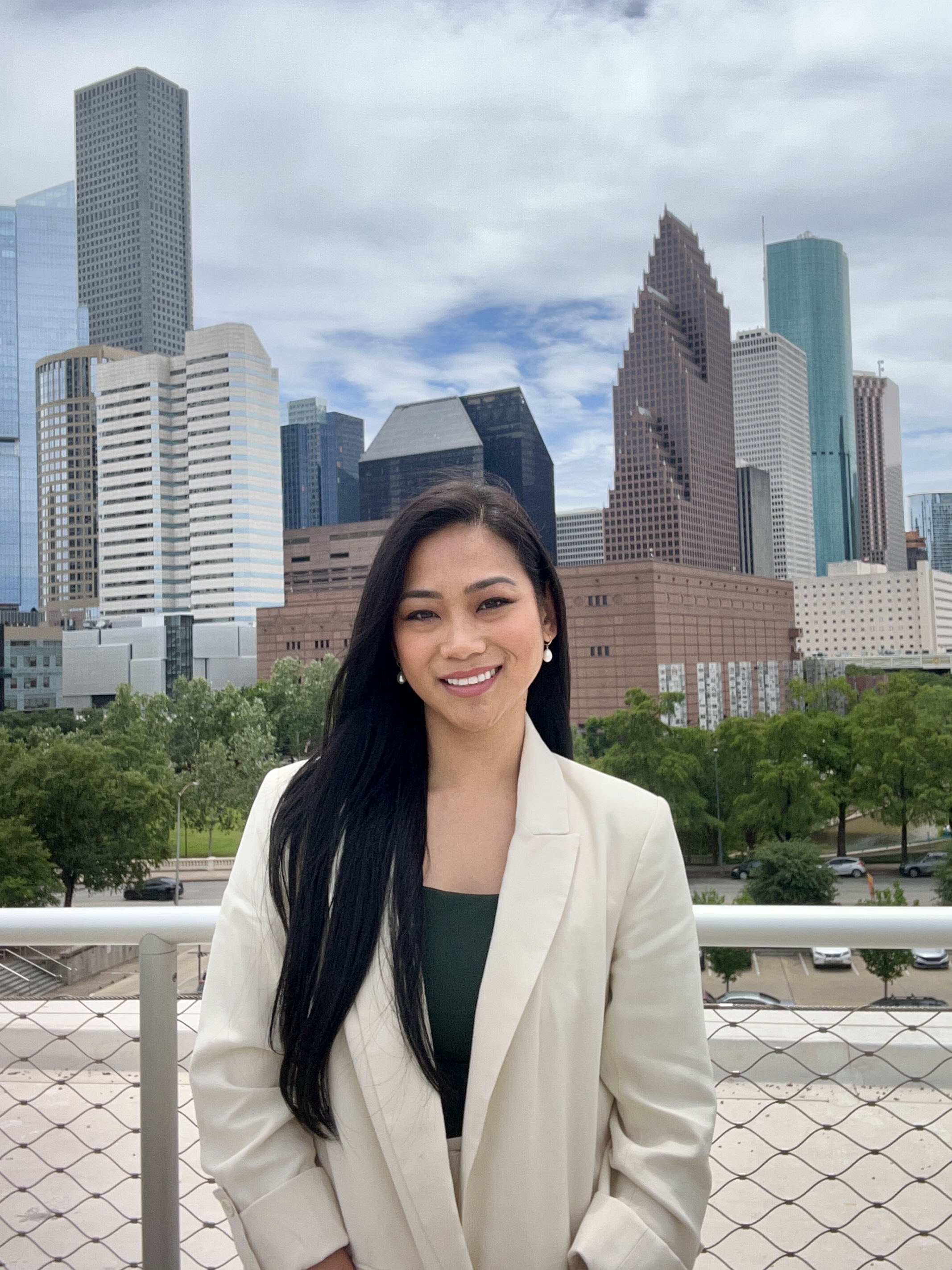 Angelica Bandayrel looks at the camera with buildings behind her.