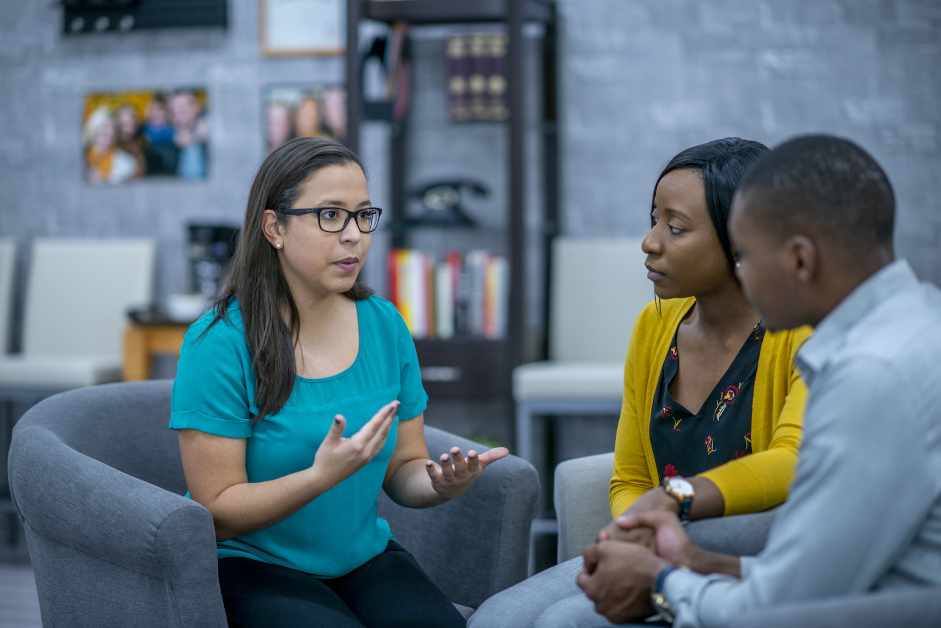 African American man and woman sitting and meeting with Asian American woman